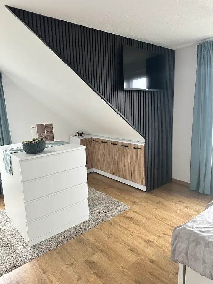 Holzpaneele mit Lamellen an einer Wohnzimmerwand in Herford